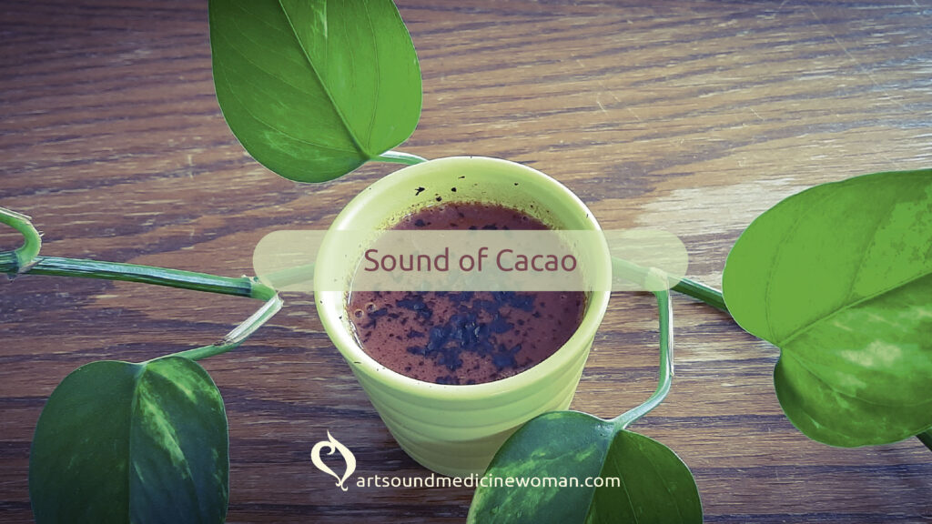 Small cup of ceremonial cacao surrounded by a vine of Pothos showing its green leaf. It is setting the atmosphere for a Sound of Cacao ceremony. Theme of the ceremony is Relax & Enjoy.