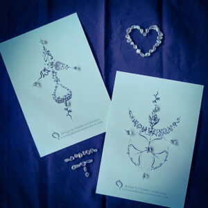 Two Soul Tattoos printed on A5 paper, arranged together on a dark blue altar cloth with little mineral stones for blessings.