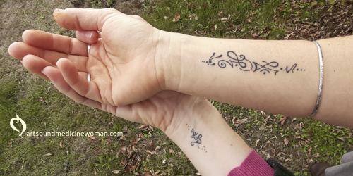 Picture showing two hands, with a Soul Tattoo on the inside of the fore arm